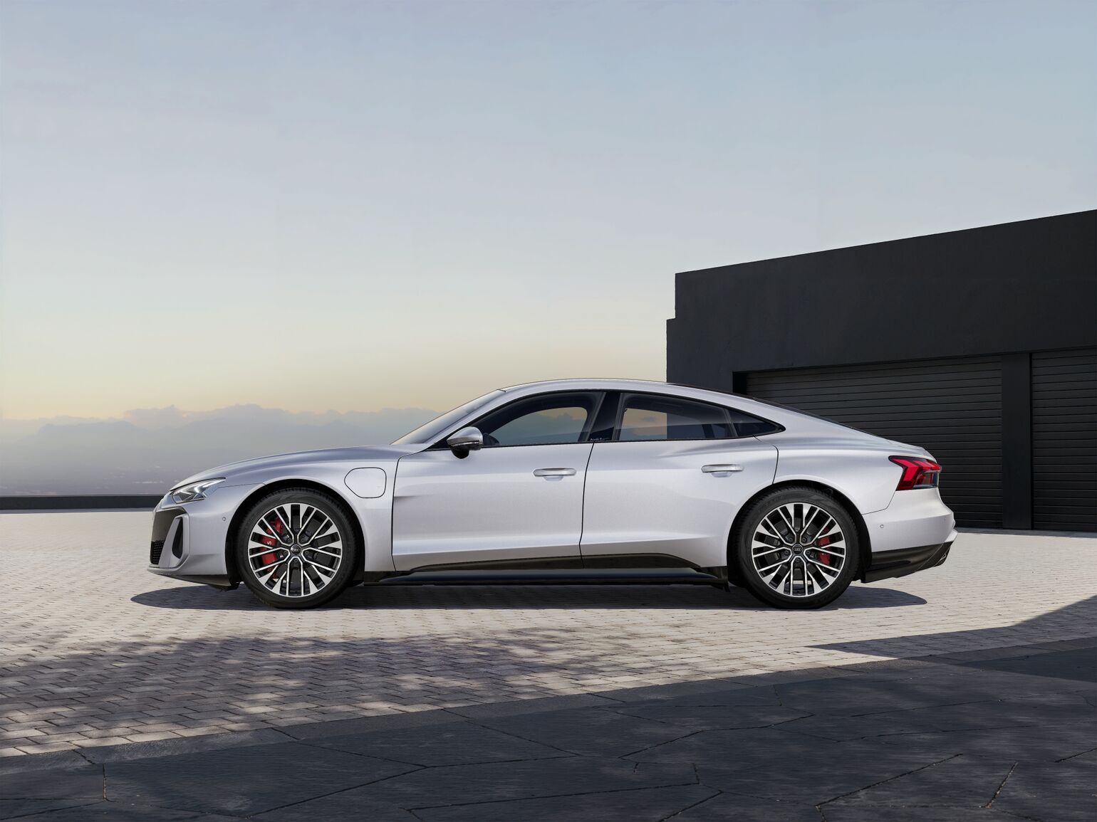 Together with optimized forms, such as the wheel arches with air flow-through, the sporty silhouette of the S e-tron GT produces particularly good aerodynamics. 20-inch wheels in multi-spoke S design with the carbide brake system and the orange brake calipers round off the dynamic side view.