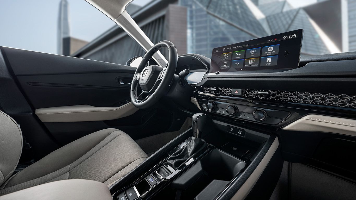 The refined interior design presents a clean, cohesive look, with a singular dash line achieved by integrating center and passenger-side vents behind an elegant mesh panel.