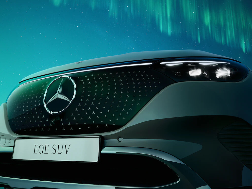 Headlamps connected by a light strip and the sporty front end with the large black panel radiator grille and central Mercedes star form the trendsetting face of the new EQE SUV.
